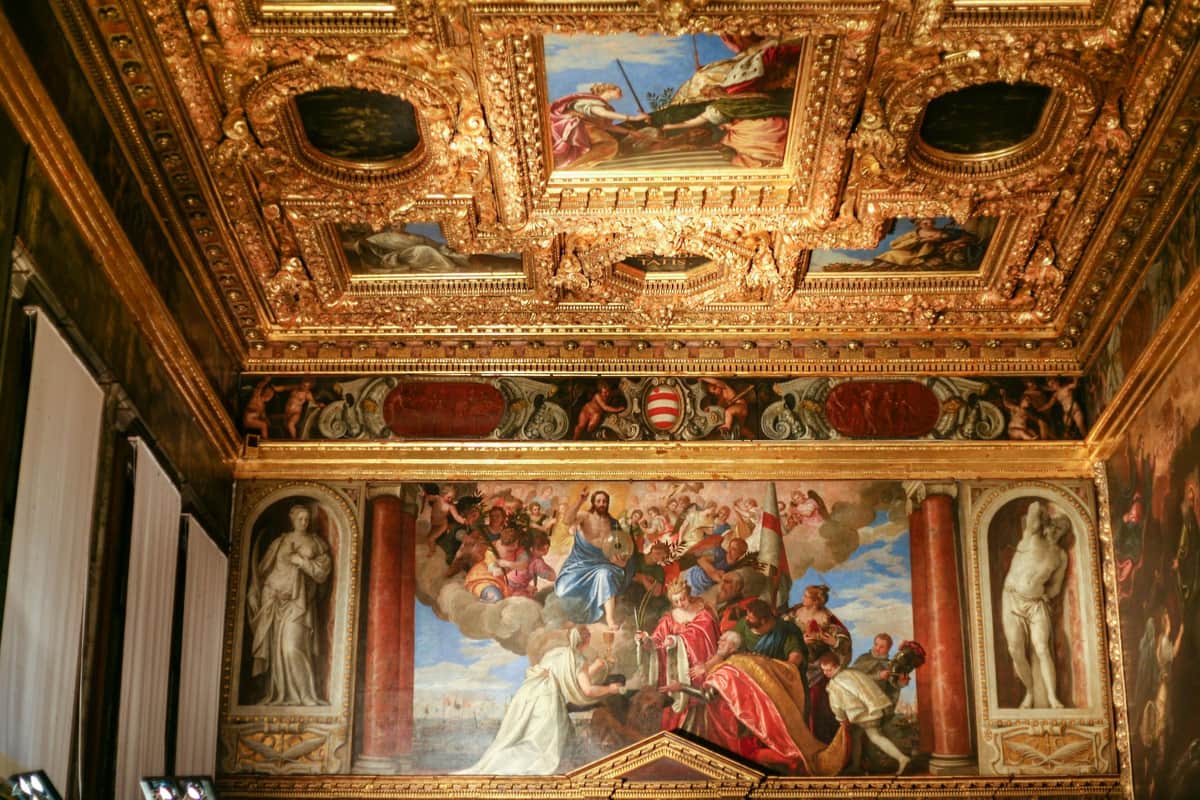 Doge's Palace & St. Mark's Basilica Combo Ornate room with a gold, intricately decorated ceiling and large mural depicting a biblical scene with multiple figures.