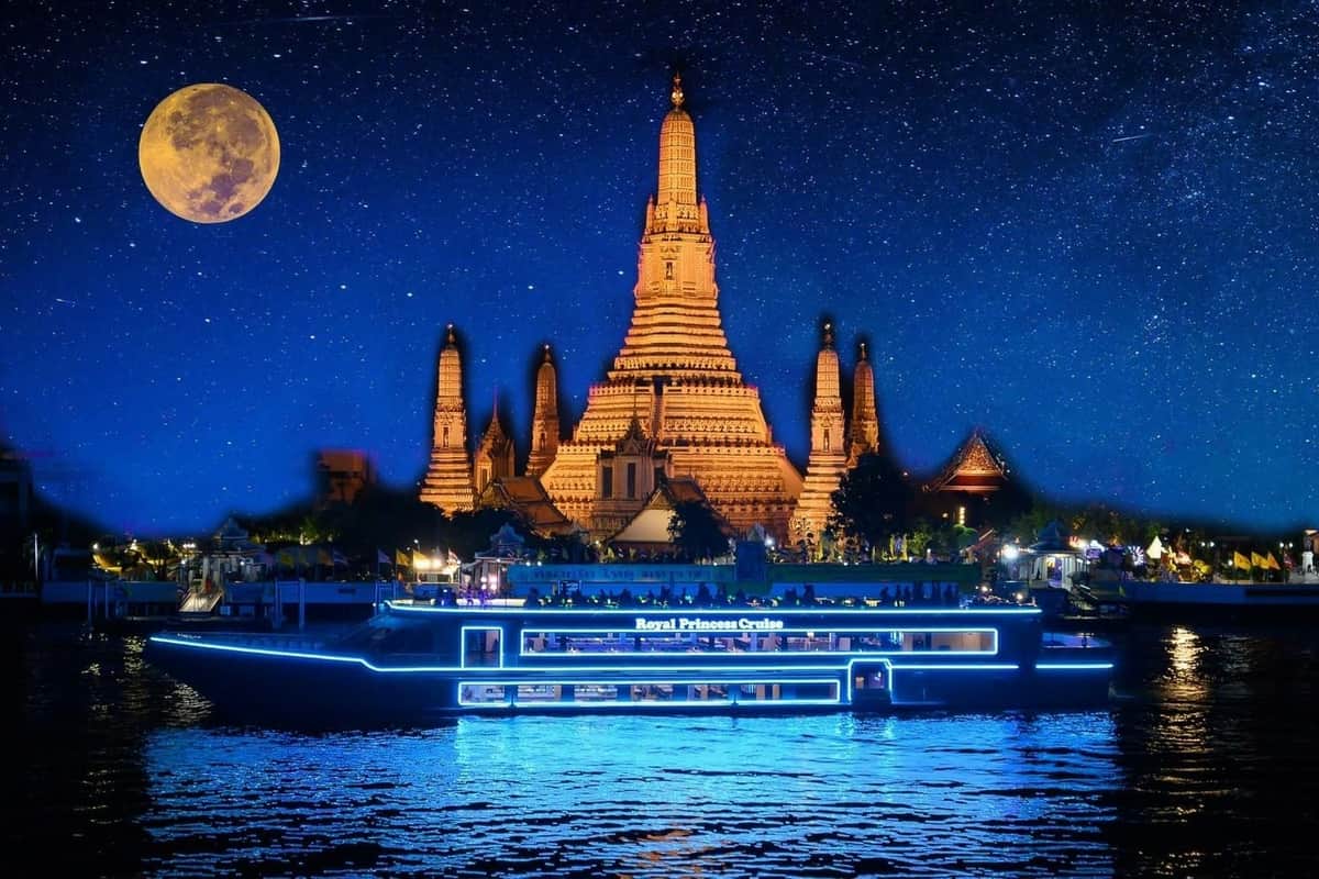 Bangkok : Croisière Royal Princess à l'Asiatique The Riverfront Pier Temple illuminé et bateau "Royal Princess Cruise" bleuissant sur l'eau sous un ciel étoilé avec une grande lune.