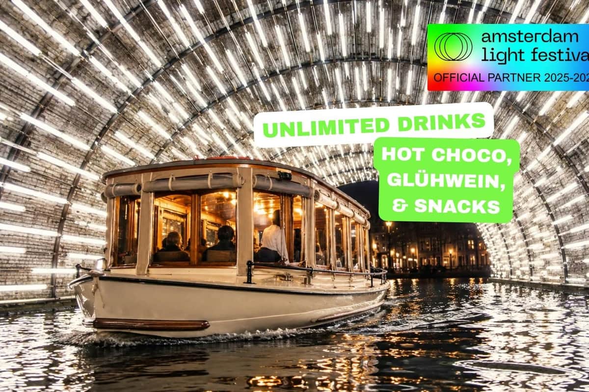 Amsterdam Light Festival: Croisière en bateau salon + boissons illimitées en option Un bateau illuminé sur l'eau, sous un tunnel de lumières, avec un texte annonçant des boissons à volonté, du chocolat chaud et des en-cas.