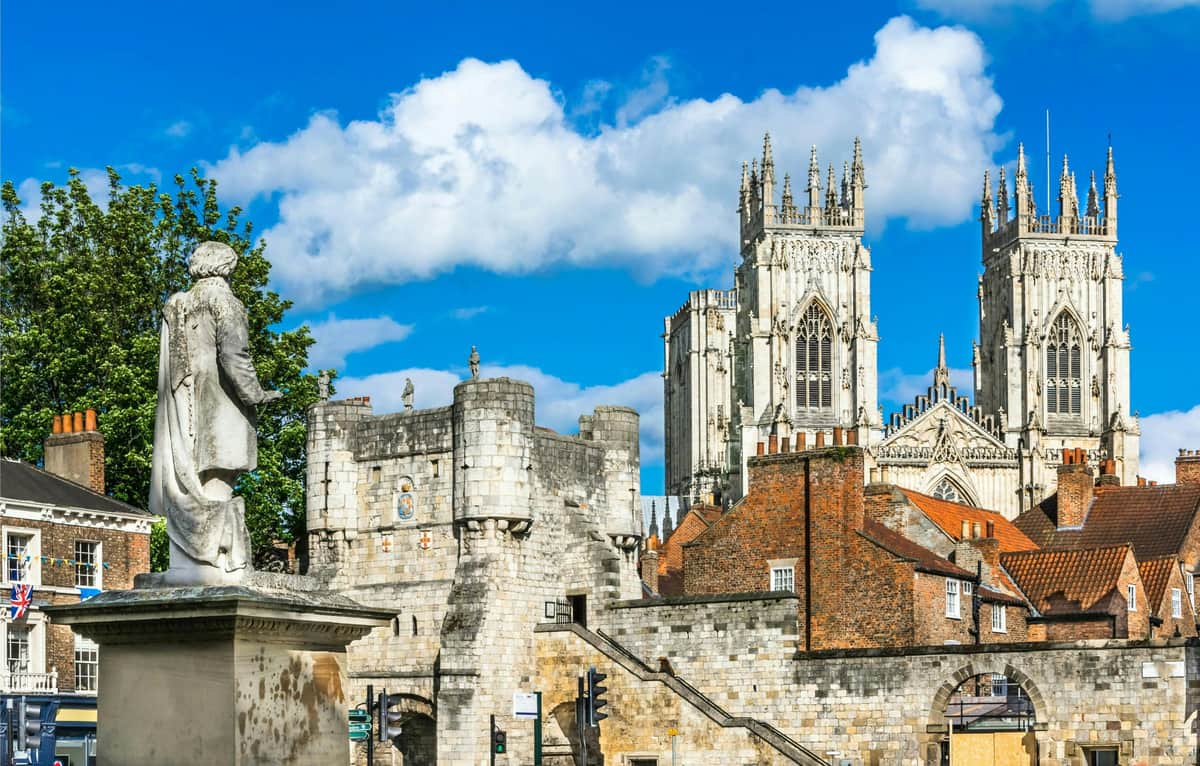 Visit York Pass : Entrée à plus de 30 attractions + Bus-on Hop-off 24 heures + Croisière Bâtiment historique orné d'un toit en dôme, entouré de haies entretenues et d'une pelouse verte, sous un ciel bleu vibrant avec des nuages.