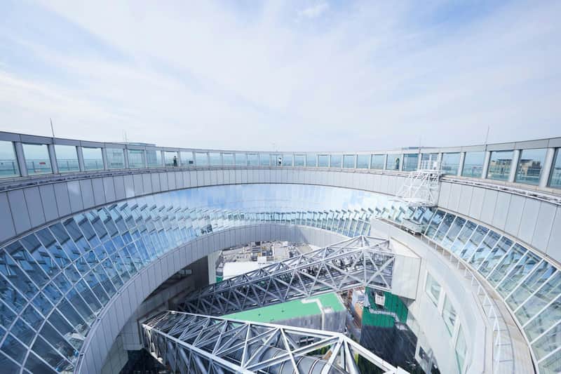 Osaka e-Pass: 2-Day Admission A modern architectural structure with glass walls and geometric metalwork, viewed from above under a partly cloudy sky.