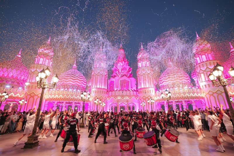 Amazing Dubai Pass: Kies 4 bezienswaardigheden Een bruisend feest met artiesten in kostuums die ’s avonds voor een verlicht, sierlijk gebouw op trommels spelen.